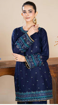 Woman wearing a navy blue embroidered dress with a beige background