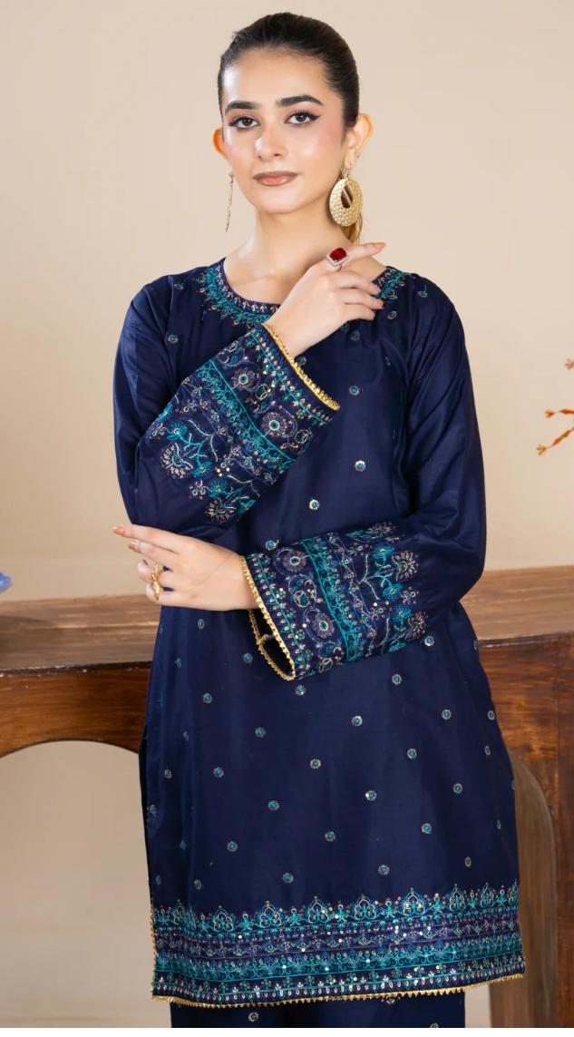 Woman wearing a navy blue embroidered dress with a beige background