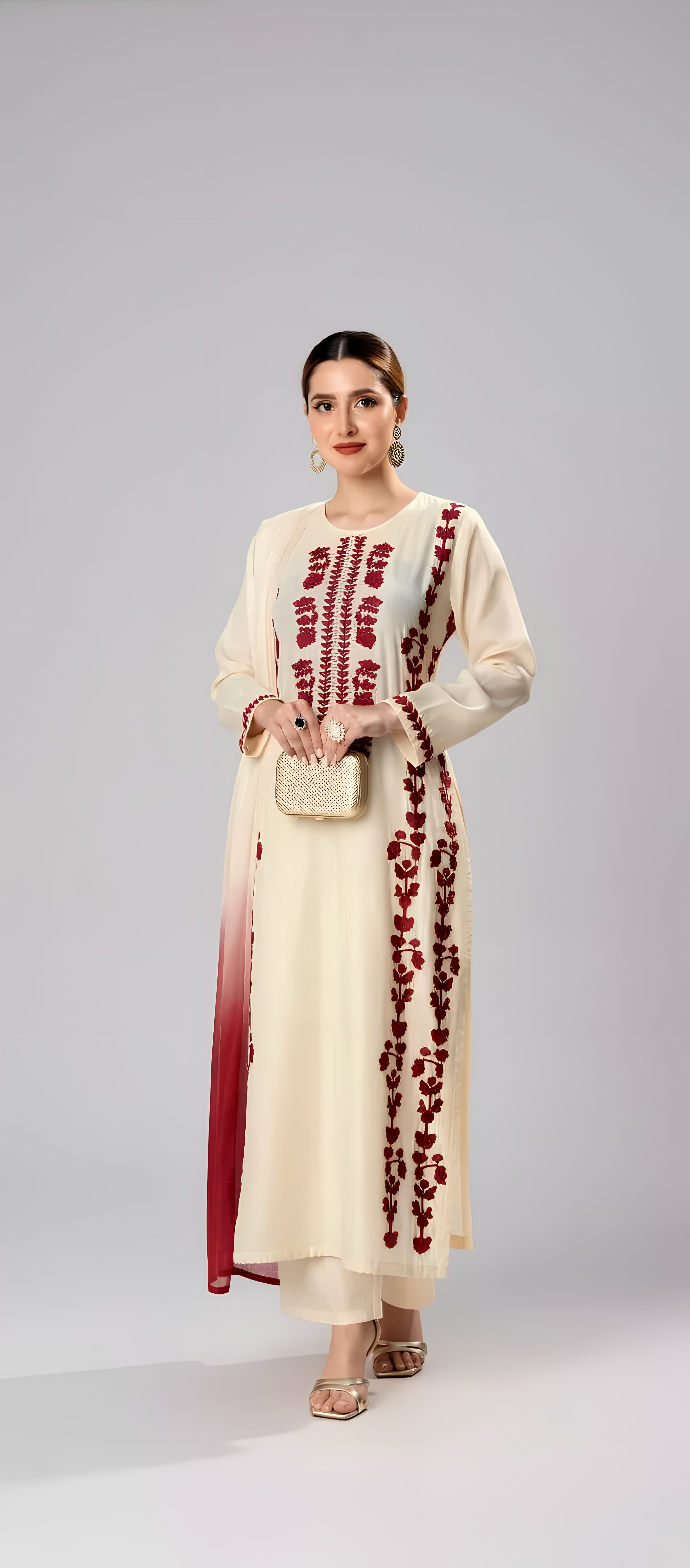 Woman wearing a cream kurta with red embroidery on a white background