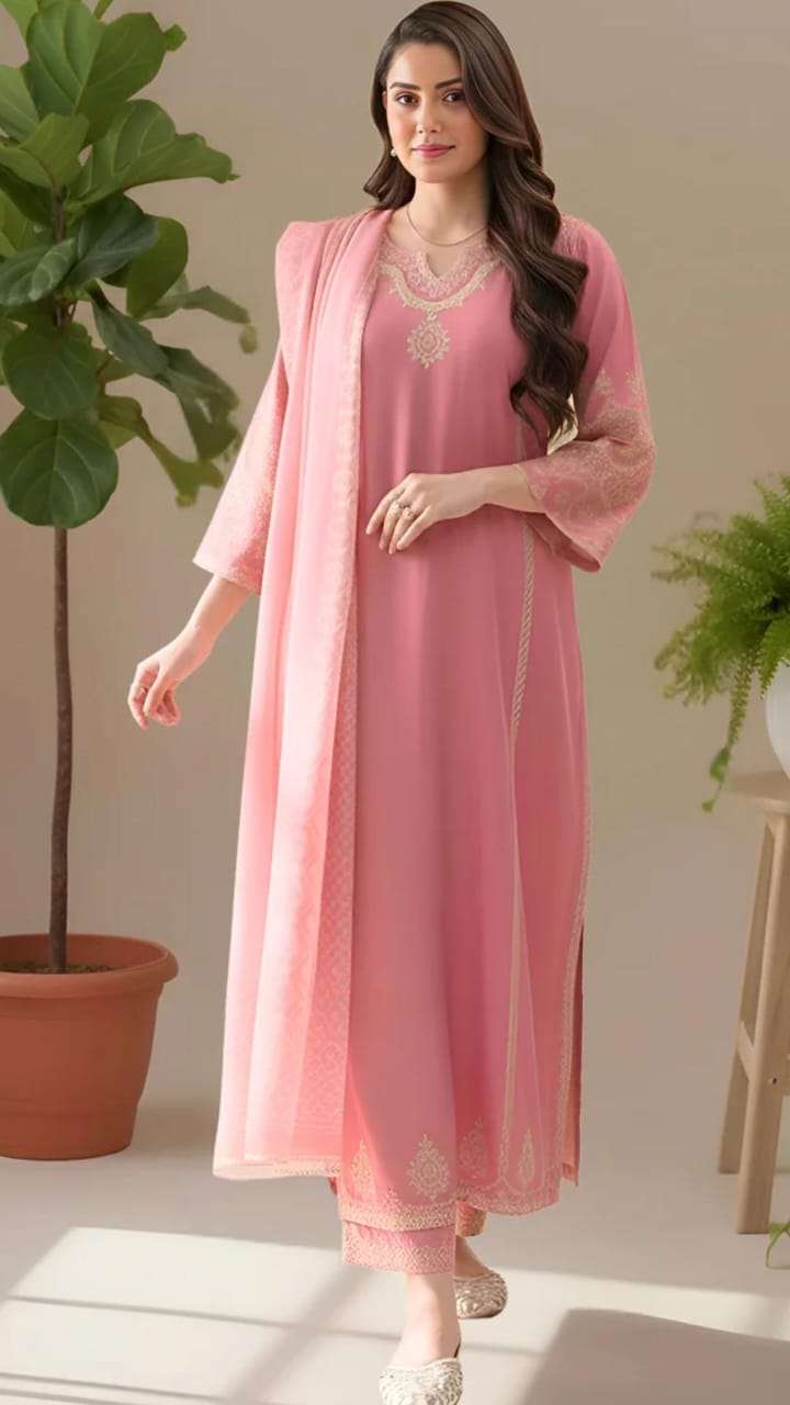 Woman wearing a pink traditional outfit with a sheer dupatta in a minimal indoor setting.