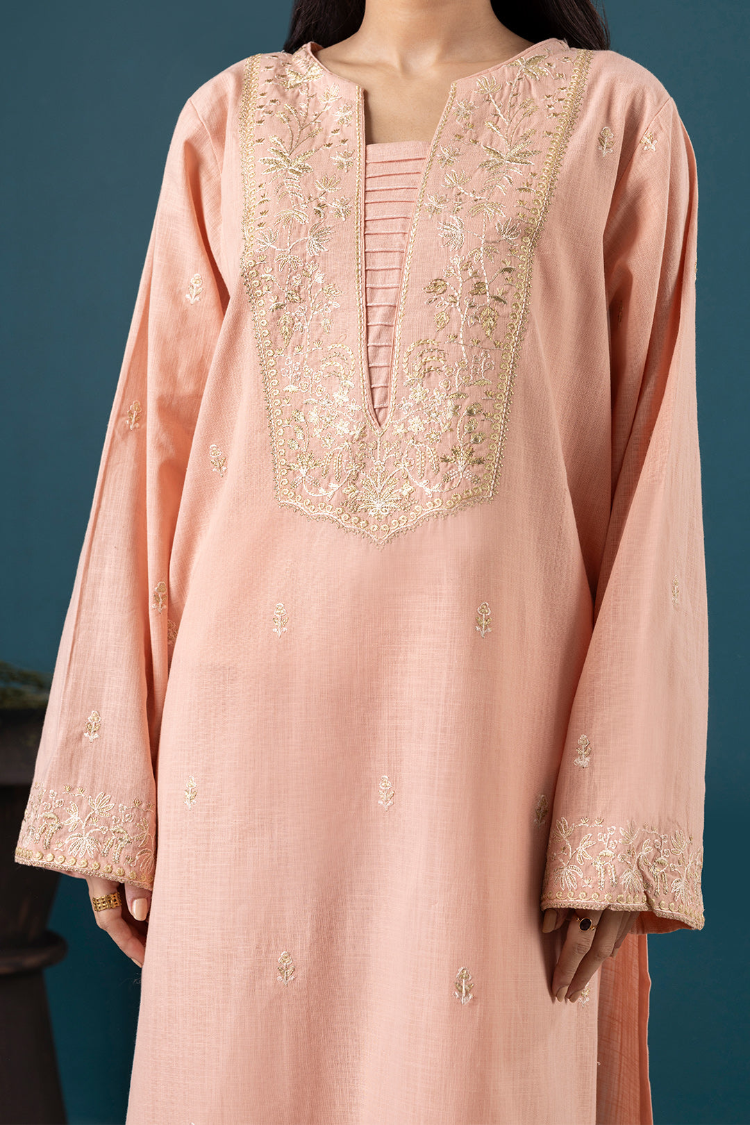 Pink embroidered dress against a dark blue background