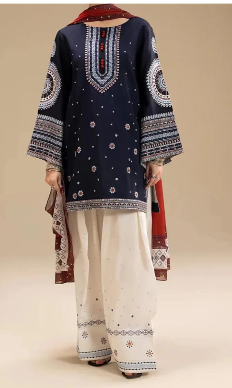 Navy blue embroidered top with white pants and a red and brown scarf on a beige background
