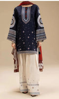 Navy blue embroidered top with white pants and a red and brown scarf on a beige background