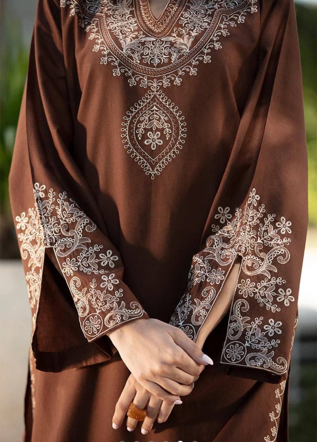 Brown embroidered garment with intricate patterns on a blurred background