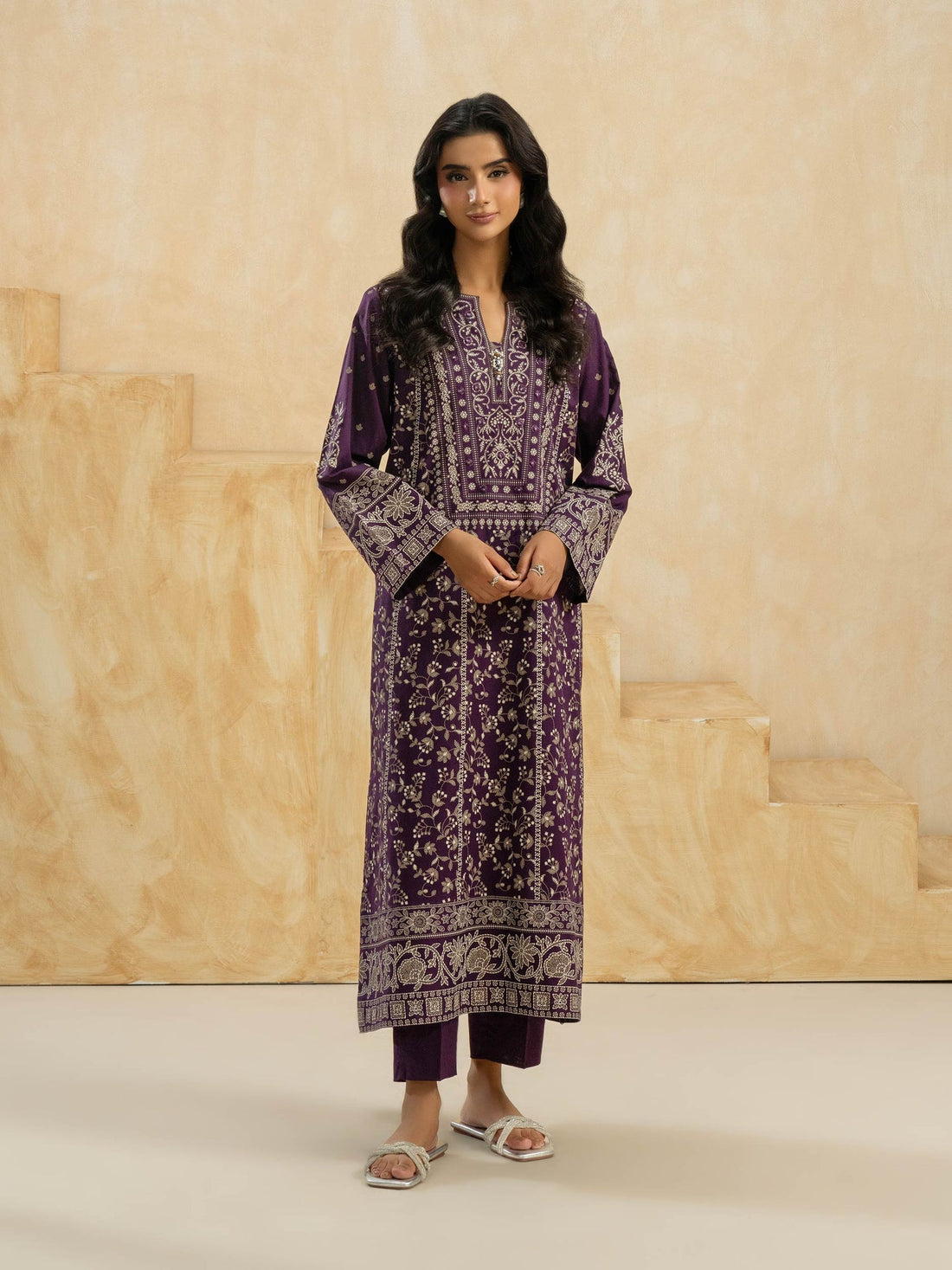 Purple patterned dress worn by a person on a beige background