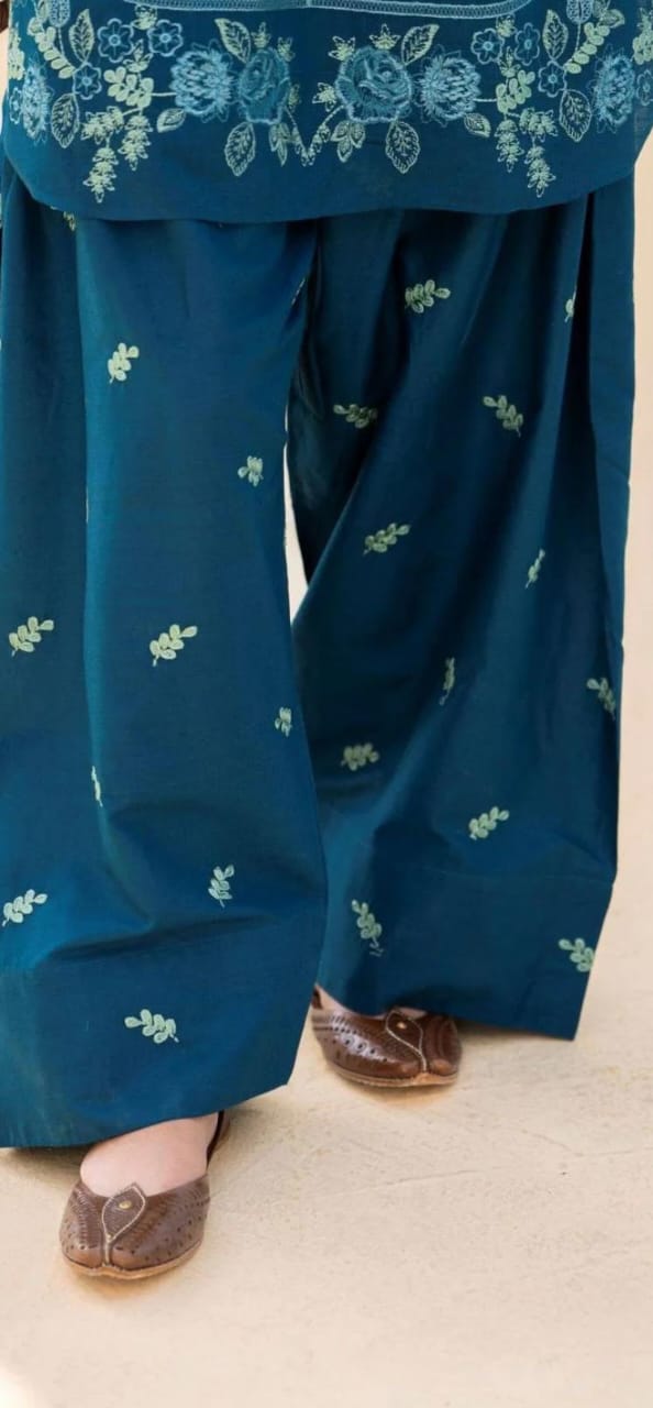 Blue traditional outfit with floral embroidery on a neutral background