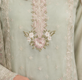 Close-up of a light green fabric with floral embroidery
