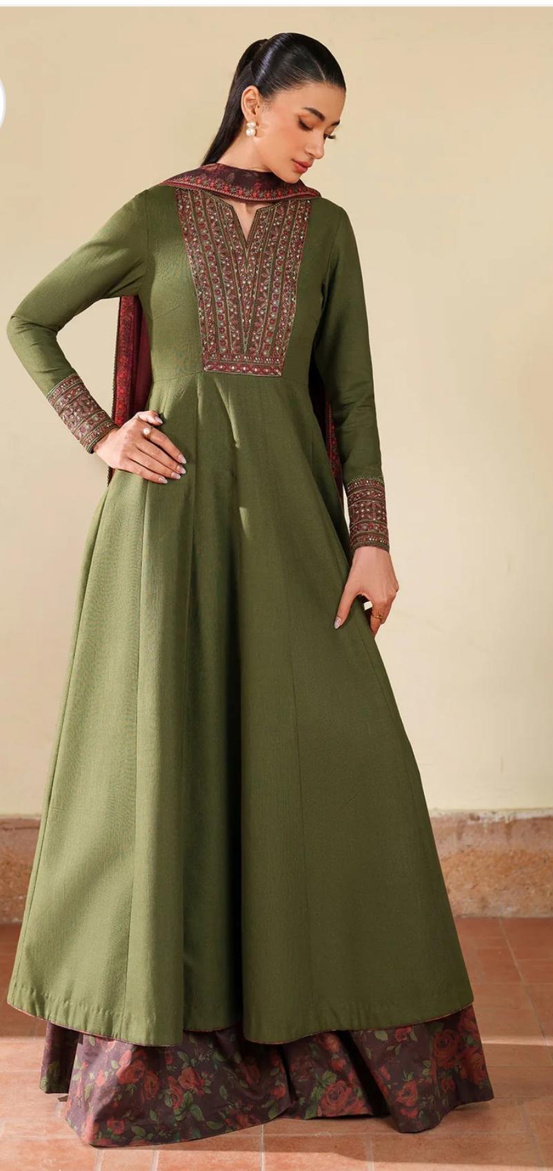 Woman wearing a green traditional outfit with maroon details on a beige background