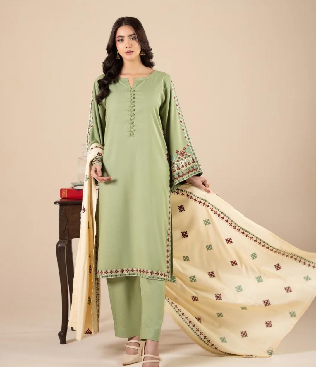 Woman wearing a green kurta with beige embroidered dupatta against a beige background