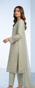 Woman wearing a light green traditional outfit with a matching dupatta on a white background