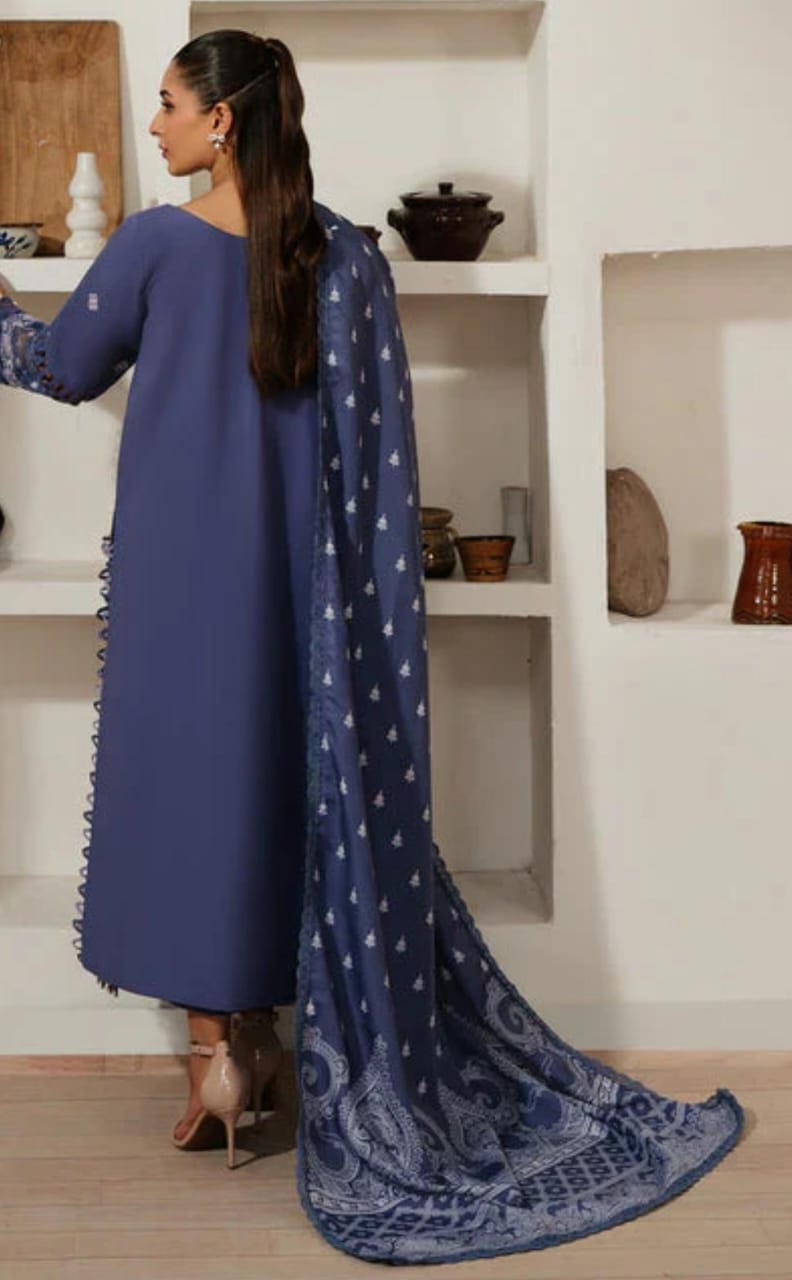 Woman wearing a blue traditional outfit with a matching dupatta in a room.