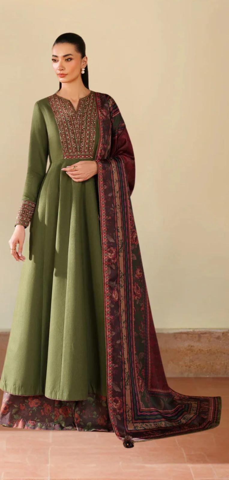 Woman wearing a green and maroon traditional outfit with a matching dupatta on a beige background