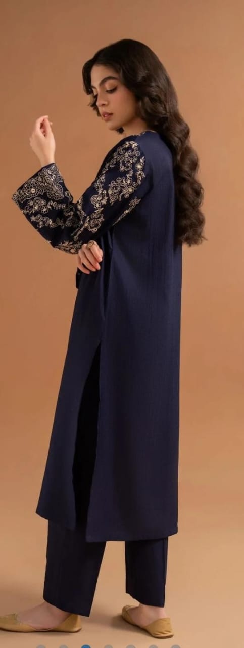 Woman wearing a navy blue kurta with floral patterns on a brown background