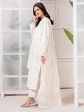 Woman wearing a white traditional outfit in a minimalistic room.