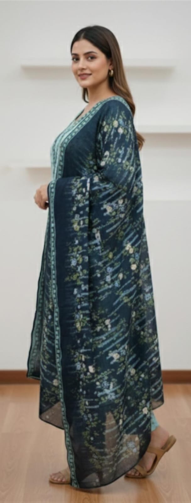 Woman wearing a long, dark blue floral-patterned dress against a white background