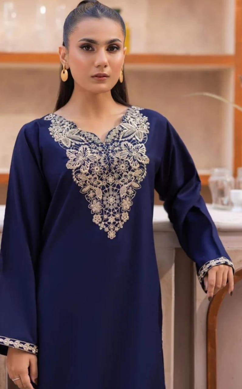 Woman wearing a blue embroidered dress indoors