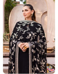 Woman wearing a black embroidered outfit with floral patterns in an outdoor setting.