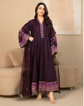 Woman wearing a dark purple embroidered outfit in an indoor setting.