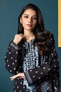 Woman wearing a black and blue embroidered traditional outfit against a teal background