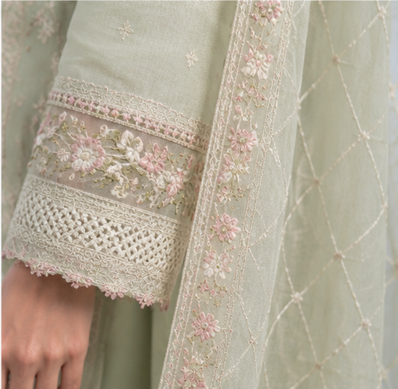 Close-up of a light green embroidered garment with floral patterns.