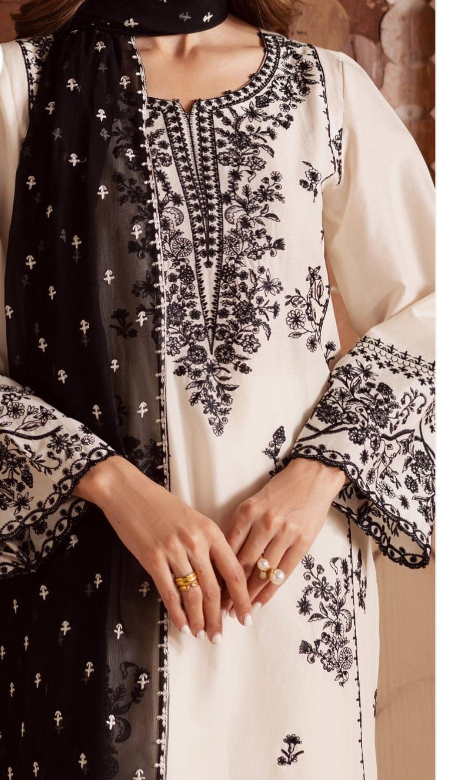 Black and white embroidered traditional outfit with floral patterns.