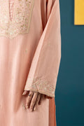 Pink dress with intricate gold embroidery against a blue background
