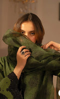 Woman holding a green garment with a blurred background