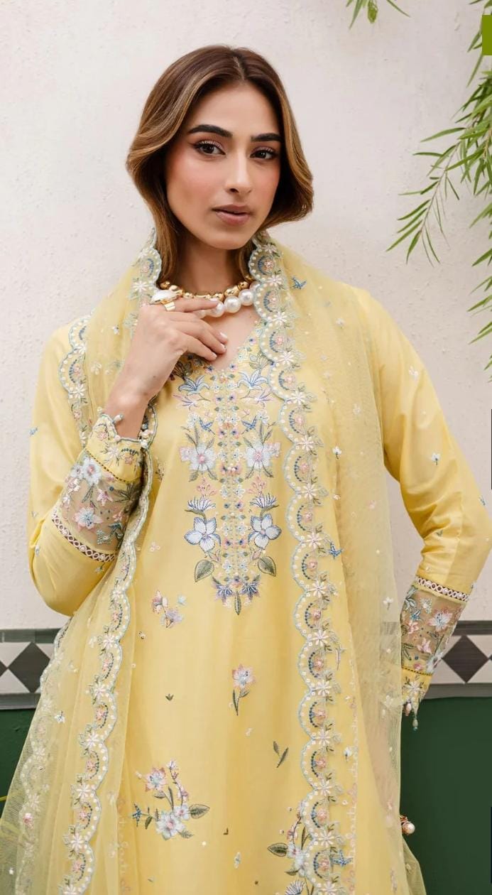 Woman wearing a yellow embroidered outfit with a floral pattern.