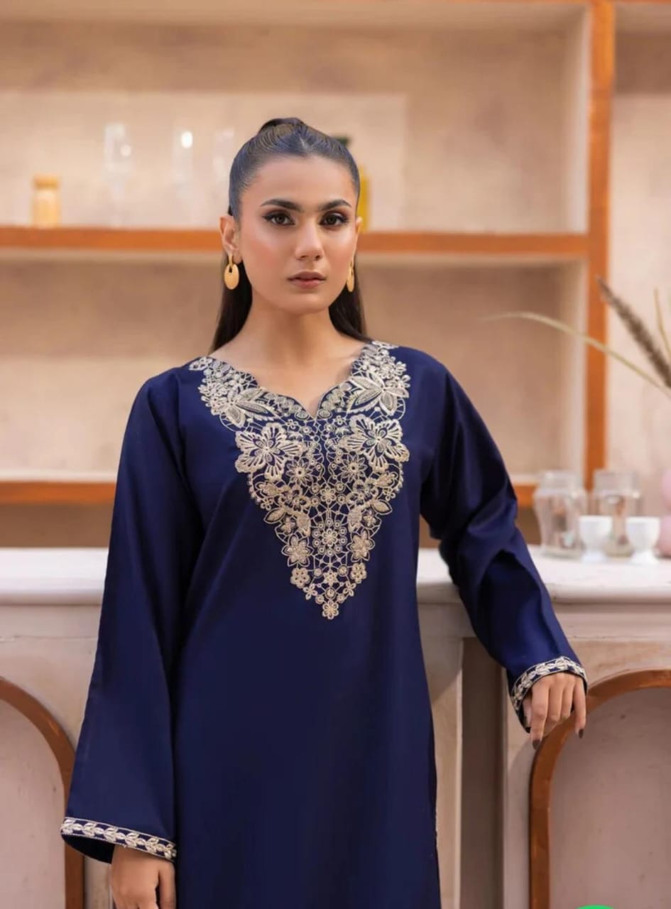 Woman wearing a blue embroidered dress in an indoor setting