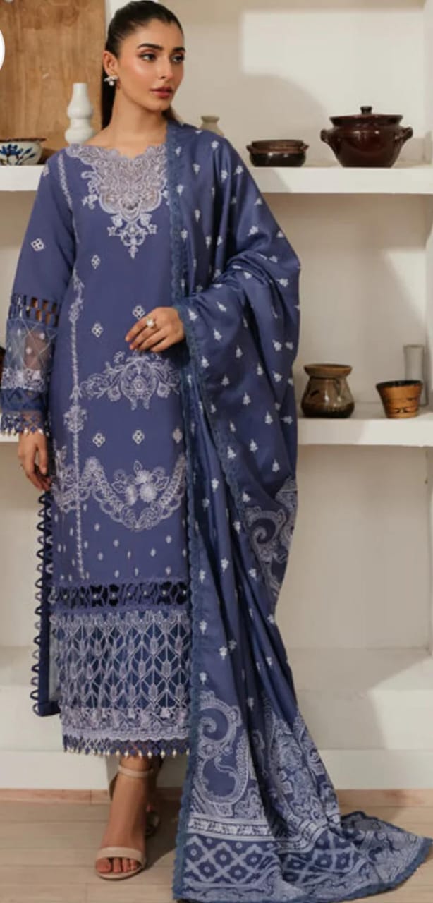 Woman wearing a blue embroidered traditional outfit with a white background