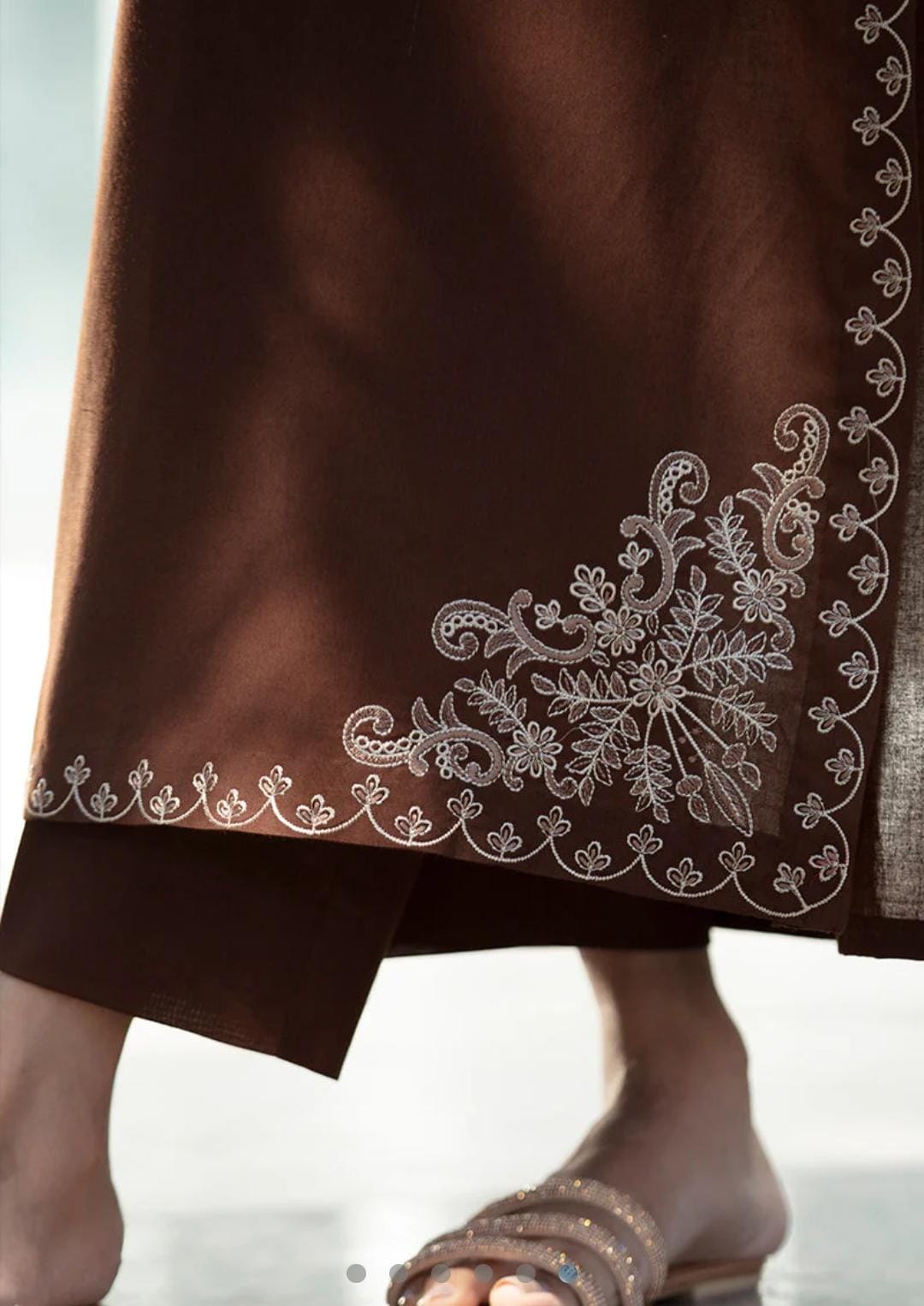 Brown fabric with white embroidery on a light background
