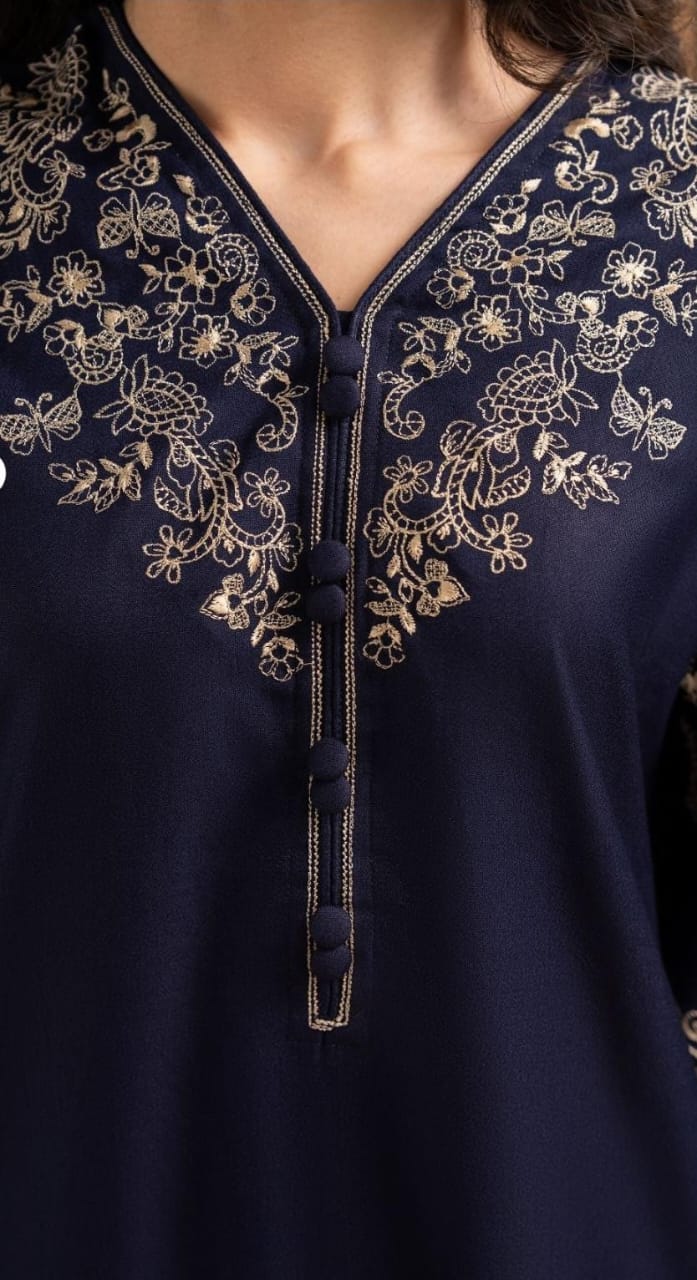 Navy blue garment with intricate gold embroidery on a blurred background