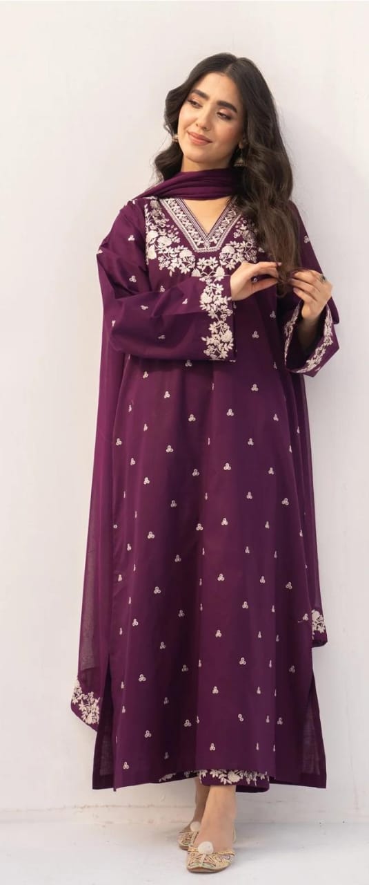 Woman wearing a long purple dress with white patterns on a white background