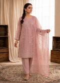Woman wearing a pink traditional outfit with a matching dupatta in a decorated room.