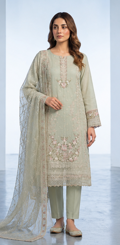 Woman wearing a light green embroidered outfit with a matching dupatta on a white background