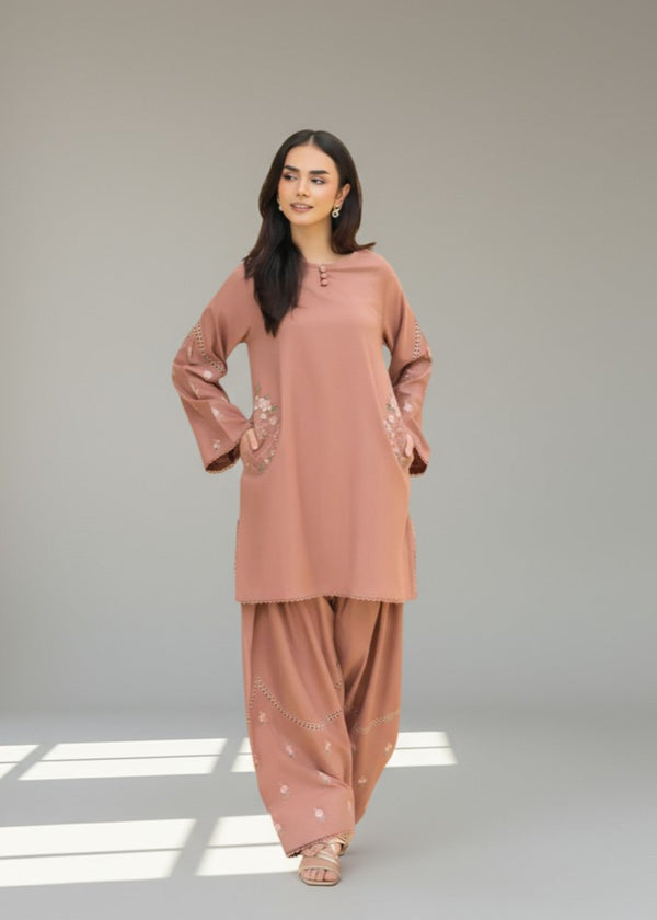 Woman wearing a matching pink kurta and palazzo set on a neutral background