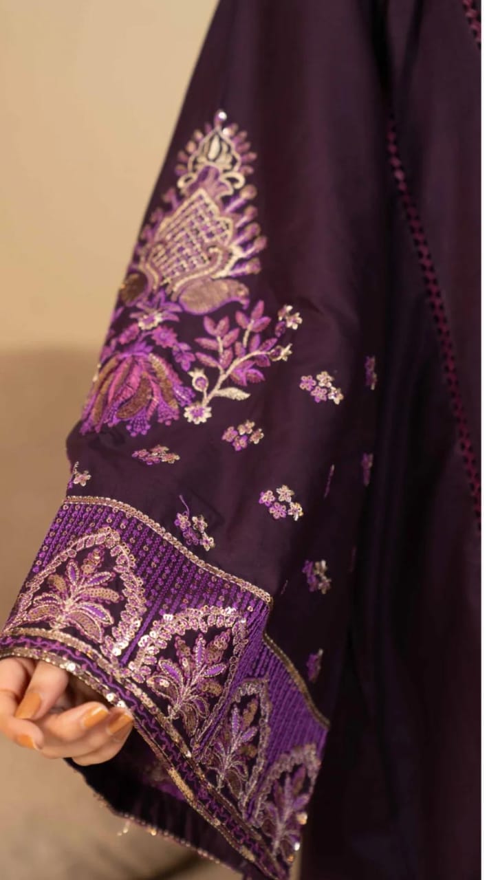 Close-up of a dark purple fabric with intricate gold embroidery